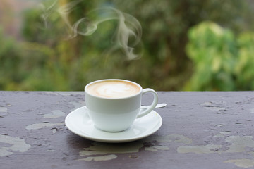 Coffee espresso on wood table nature background in garden,warm tone