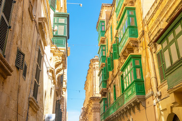 Fototapeta na wymiar Maltese streets and colorful wooden balconies in Valletta, Malta