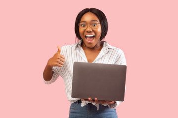 Girl Holding Laptop Gesturing Thumbs-Up Recommending Website Standing In Studio