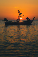 Atmosphere of the beach at sunset, fishing boats moored on the sandy beach