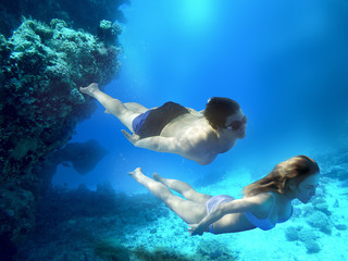 Young guy and girl dive in the tropical sea