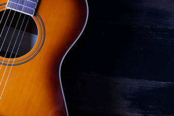 Cropped image of vintage style travel size acoustic guitar with rosewood neck and no pickguard on...