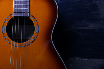 Cropped image of vintage style travel size acoustic guitar with rosewood neck and no pickguard on...