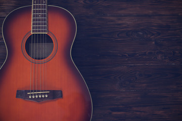 Cropped image of vintage style travel size acoustic guitar with rosewood neck and no pickguard on...