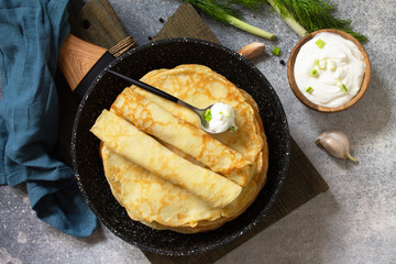Stack Potato pancakes, not sweet, served with garlic cream sauce on a gray stone background. Top view flat lay background.