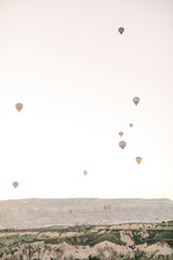 Hot air balloons flying over rock landscape in Love valley at Cappadocia, Turkey 