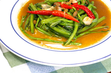 Stir fried Chinese morning glory with fish sauce and red chili in white dish, thai food