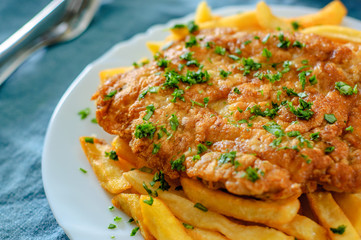 Fish and Chips. Fried fish fillet and potatoes in a white plate on table