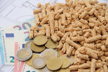 wood pellets with money on a floor plan