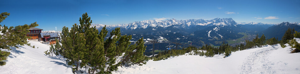 wintry landscape at Wank mountain, view to Zugspitze and tourist resort Garmisch-Partenkirchen, wooden alp hut
