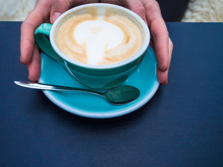 woman holding hot cup of coffee, with beautiful art shape, Closeup of female hands and mug of latte