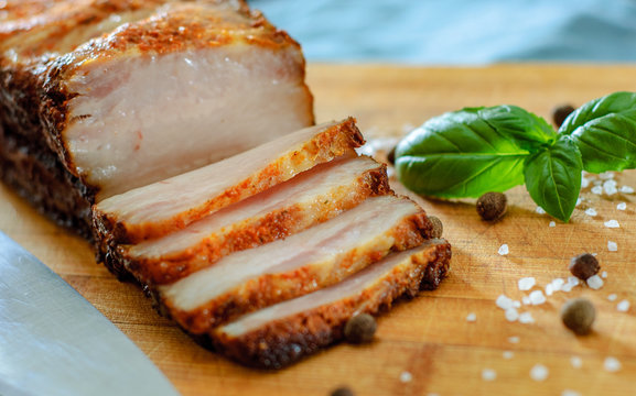 Close up view of a piece of roasted pork belly on wooden cutting board