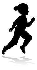 A child in silhouette playing in Christmas or winter cold weather clothing