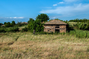 Old rural country stone house facade in sunny summer day