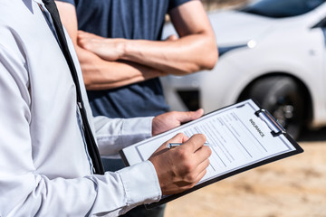 Insurance Agent examining car crash and customer assessed negotiation, checking and signing on report claim form process after accident collision, Accident and insurance concept