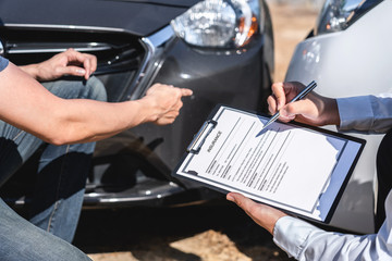 Insurance Agent and customer assessed negotiation, checking and signing on report claim form process after accident collision, Traffic Accident and insurance concept