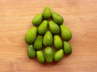 Bunch  of green avocados on a wooden background.