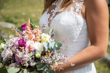 Détail de la robe de la marié avec son bouquet le jour de son mariage