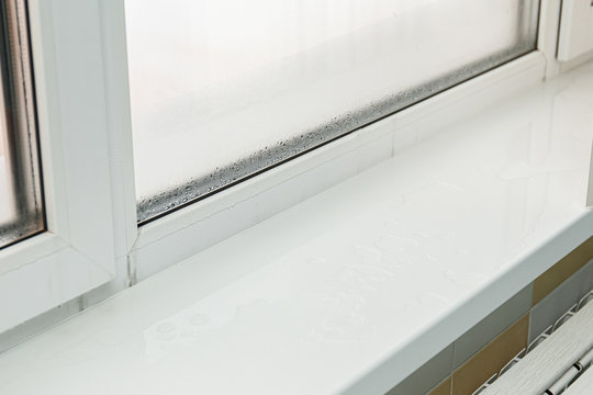 Plastic window with damp and water condensation on glass