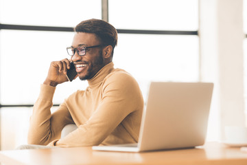 Cheerful black guy talking on the phone