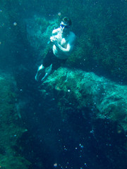 Fototapeta premium Man free diving from underwater cave in blue hole in Florida.