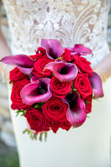 Détail de la robe de la marié avec son bouquet le jour de son mariage