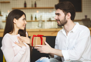 Young millennial man congratulation his girlfriend with present