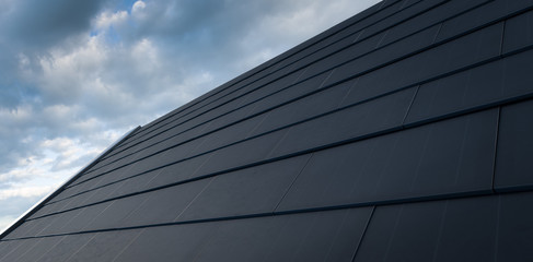 Fototapeta na wymiar Black solar roof concept. Building-integrated photovoltaics system consisting of modern monocrystal black solar roof tiles. 3d rendering.