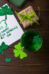 St. Patrick's Day Green Beer pint over dark green background, decorated with shamrock leaves. Patrick Day pub party, celebrating.