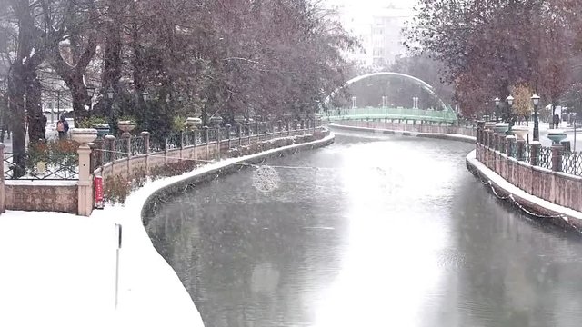 Beautiful Snow Landscape of Porsuk River with bridge and trees at the background in Winter season, in Eskisehir, Turkey. Beautiful view of snow in city center.