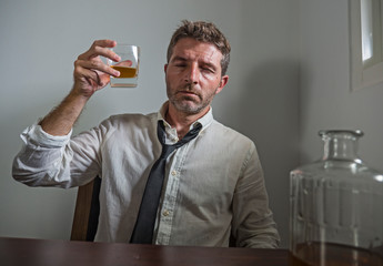 portrait of 30s to 40s alcoholic  man in lose necktie drinking desperate holding whiskey glass...