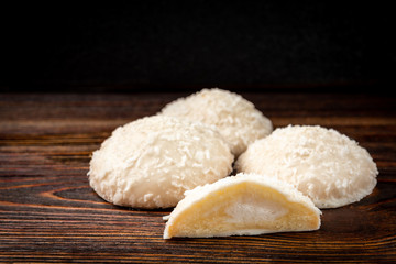 Fototapeta na wymiar Biscuit cookies with coconut filling on dark wooden background.