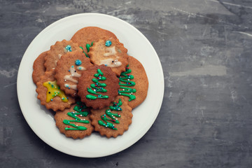 cookies with Christmas decoration on white plate on ceramic background