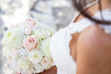 Détail de la robe de la marié avec son bouquet le jour de son mariage
