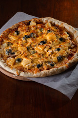 Pizza on a wooden dark background in a bar