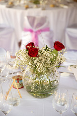Décoration de table avec des roses rouges le jour d'un mariage