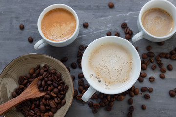 Obraz na płótnie Canvas cups of coffee with milk and grains on ceramic background