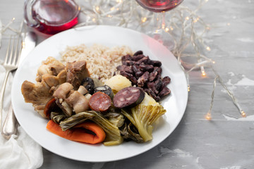 typical portuguese dish boiled meat, smoked sausages, vegetables and rice on white plate