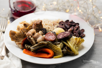 typical portuguese dish boiled meat, smoked sausages, vegetables and rice on white plate