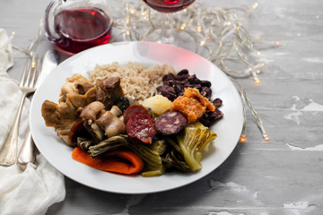 typical portuguese dish boiled meat, smoked sausages, vegetables and rice on white plate