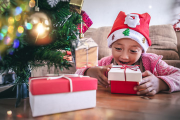 Happy little girl looking to Christmas gift box, Christmas and New Year concept.