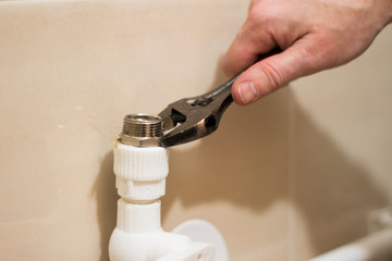 Installation hoses for washers domestic connection plumbing pipes. Adjustable wrench and plastic tube closeup.