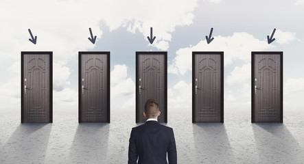 Back view of businessman choosing the right door