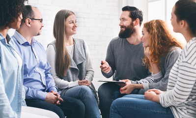 Therapist talking with patients during support group session - obrazy, fototapety, plakaty