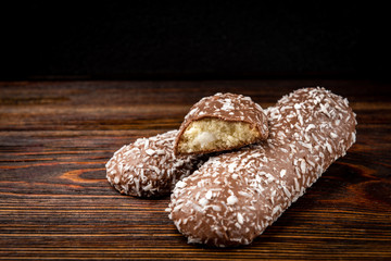 Chocolate cookies with coconut on dark wooden background.