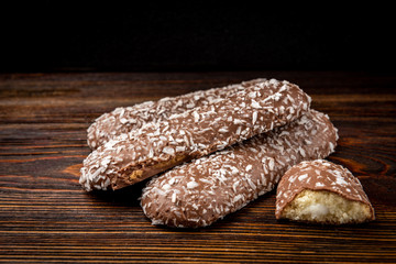 Chocolate cookies with coconut on dark wooden background.