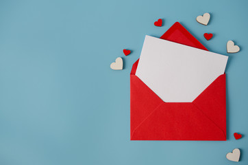 Valentines day greeting card. Red envelope with blank card on blue background.