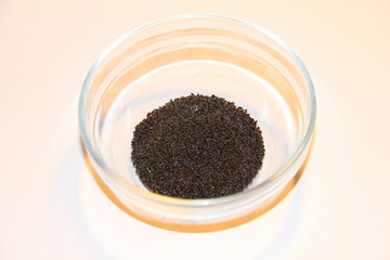 pile of basil seeds tukmaria in glass bowl on white background