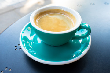 A cup of coffee on the table. A fresh morning coffee time in downtown street cafe.  