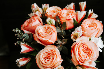  large luxurious bouquet of peony roses of coral color with white freesia in noir style on a dark background. dark romance